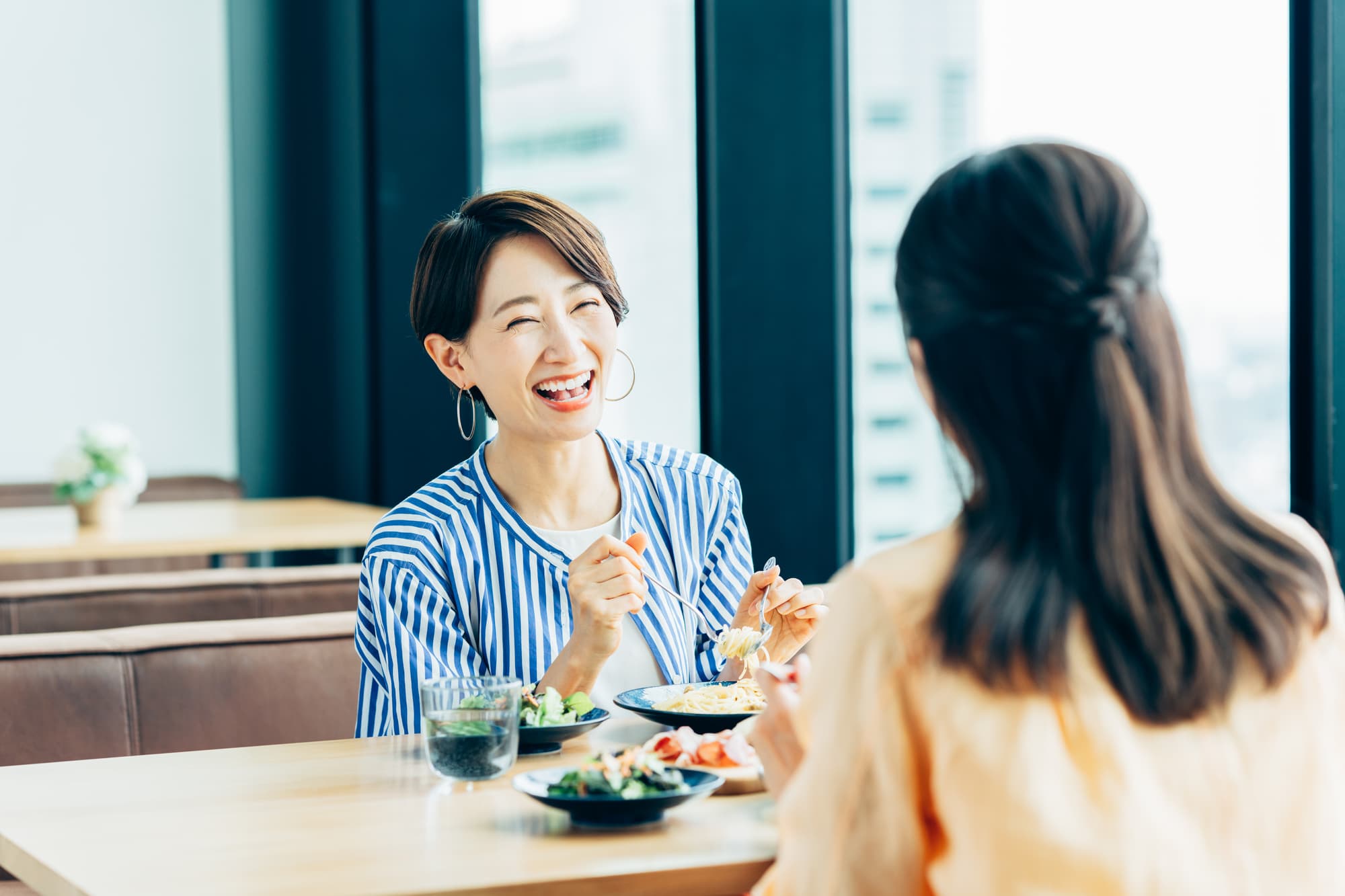根管治療を終えて友人と食事を楽しむ女性