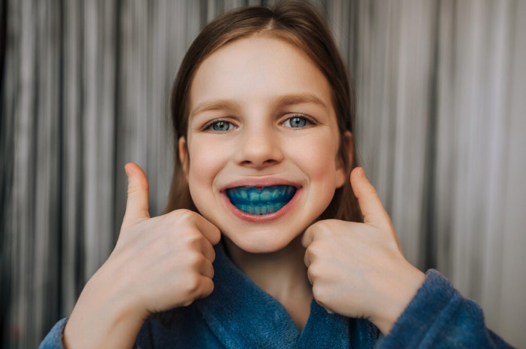 プレオルソを装着して両手でグッドサインをする子ども